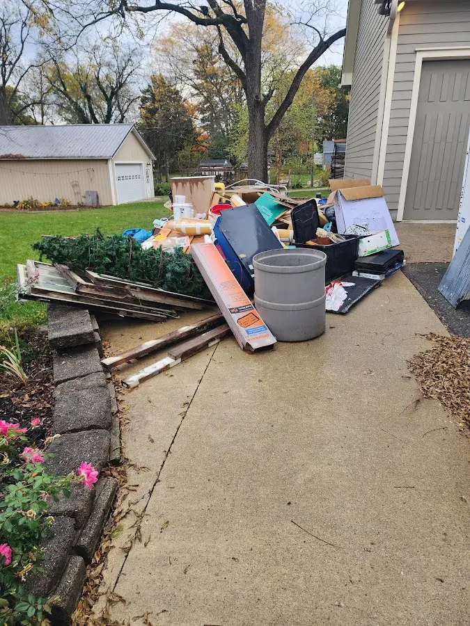Dumpster being loaded with debris for 12 Yard Dumpster Rental in Iron River